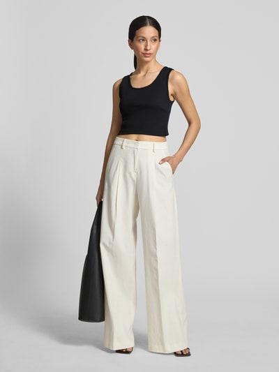 Kobiece modelka nosi czarny top Slim Fit Top mit Zierbordüre Modell 'Tiora' od Drykorn z bawełny, krój slim fit, długość tyłu 33 cm, widok całej sylwetki z przodu.