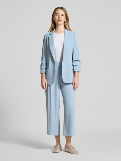 Frauenmodel trägt hellblauen Relaxed Fit Blazer mit Pattentaschen von Jake*s Collection im Material-Mix mit Stretch-Anteil, Ganzkörperansicht von vorne.