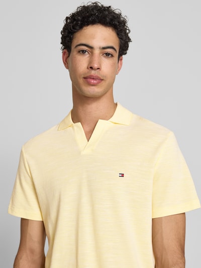 Männermodel trägt Regular Fit poloshirt aus zuiver katoen von Tommy Hilfiger, melangelook, gestikt logo, polokraag, korte mouw, V-hals, nahaufnahme bovenlichaam.