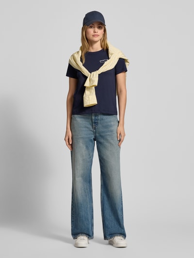 Modelka nosi T-Shirt mit Label-Print und Rundhalsausschnitt od Gant, granatowy kolor, regular fit, bawełna, jeansy, pełny widok z przodu.