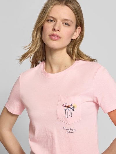 Frauenmodel trägt Regular Fit T-Shirt aus reiner Baumwolle Modell 'POLLY' von Only, Optik: Unifarben, Stickerei, Rundhals, Kurzarm, Brusttasche, Nahaufnahme Oberkörper.