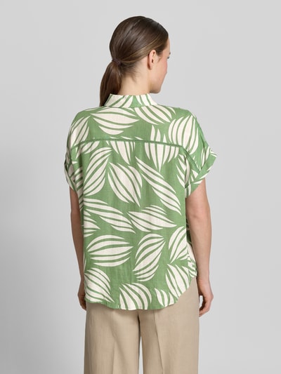 Frauenmodel trägt Bluse aus Viskose-Mix mit Brusttasche von Apricot mit grünem und cremefarbenem Blattmuster, Loose-Fit, Hemdblusenkragen, Knopfleiste, Ärmel mit Aufschlag, Rückenlänge 65 cm bei Größe S, Ganzkörperansicht Rückansicht.