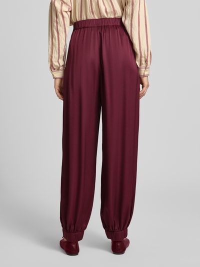 Frauenmodel trägt Haremshose aus Viskose mit elastischem Bund von Jake*s Collection in dunklem Rot, Relaxed Fit, Ganzkörperansicht Rückansicht.