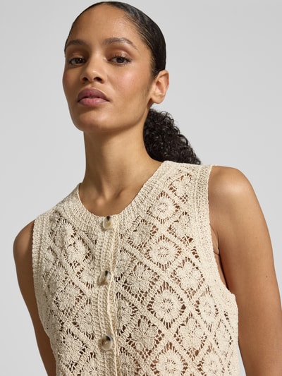 Frauenmodel trägt Strickweste mit Rundhalsausschnitt und Knopfleiste von JAKE*S STUDIO WOMAN in Beige mit gehäkeltem Muster, Nahaufnahme Oberkörper.
