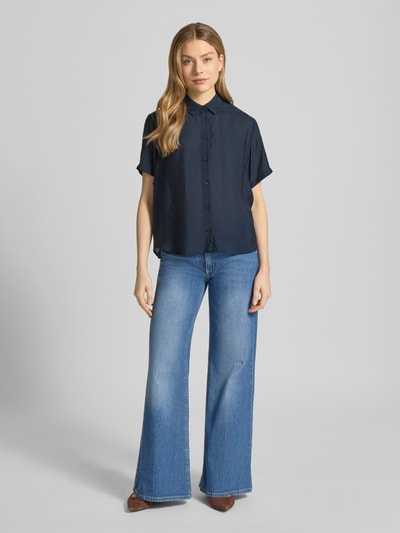 Frauenmodel trägt Relaxed Fit Bluse aus Modal-Mix mit Seiden-Anteil Modell 'MINA' von Samsøe Samsøe in Dunkelblau, kurzärmlig, Hemdblusenkragen, kombiniert mit heller Jeans, glatte Textur, Ganzkörperansicht von vorne. Rücklänge und Ärmellänge bei Größe S: 62 cm und 21 cm.
