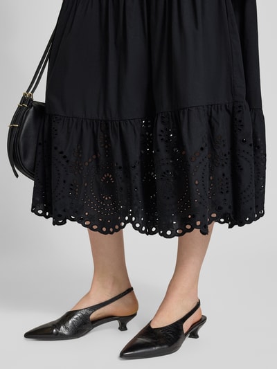 Frauenmodel trägt Midirock mit Lochstitching von Christian Berg Woman Selection in Schwarz, reine Baumwolle, leichte A-Linie, Nahaufnahme Unterkörper.