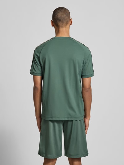 Männermodel trägt T-Shirt aus Viskose-Mix mit Logo von EA7 Emporio Armani, Regular-Fit, Rundhalsausschnitt, Rückenlänge 70 cm, Ganzkörperansicht Rückansicht.