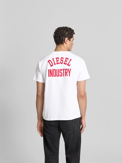 Männermodel trägt Regular Fit T-Shirt aus reiner Baumwolle von Diesel, weiße Farbe, Rundhalsausschnitt, Label-Applikation, Rückenansicht, kurzärmeliges Design, Herren T-Shirt, Rückenlänge 70 cm bei Größe M. Ganzkörperansicht Rückansicht.
