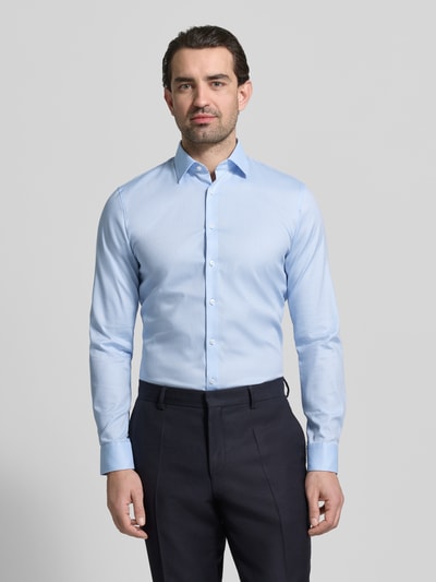 Męski model nosi Slim Fit Businesshemd mit Kentkragen od OLYMP No. Six, jasnoniebieska gładka bawełna elastyczna, krój slim fit, kołnierz kent, pełna listwa guzikowa, długie rękawy, rękawy sportowe, długość tyłu w rozmiarze 40: 81 cm, szerokość ramion w rozmiarze 40: 43 cm, długość rękawa w rozmiarze 40: 67 cm, widok całej sylwetki z przodu.