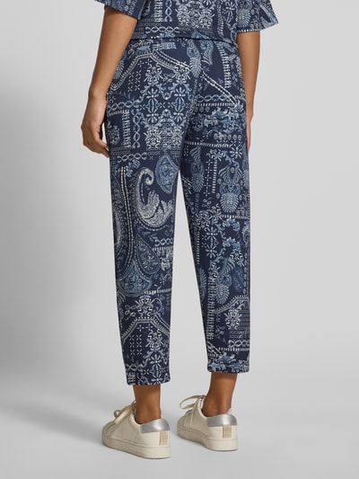 Frauenmodel trägt Regular Fit Hose aus Viskose-Mix von Christian Berg Woman mit Allover-Paisley-Print in Blau, elastischer Bund, verkürzte Passform, Ganzkörperansicht Rückansicht.
