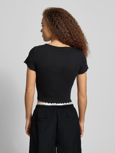 Männermodel trägt Slim Fit T-Shirt aus Baumwoll-Mix von Tommy Jeans, czarny, krój slim fit, frill na rękawach i dolnym brzegu, widok z tyłu, Ganzkörperansicht Rückansicht.