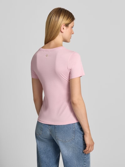 Frauenmodel trägt T-Shirt mit Perlen und Rundhalsausschnitt Modell 'Tamme' von JOOP!, hellrosa, glatte Textur, Ganzkörperansicht Rückansicht. Damen T-Shirt aus reiner Baumwolle, Regular Fit, Rückenlänge bei Größe 36: 58 cm.