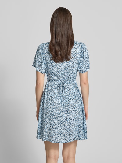 Frauenmodel trägt Minikleid aus reiner Viskose Modell 'EVIDA' von Only mit Allover-Muster in Blau, tailliert, Ganzkörperansicht Rückansicht.