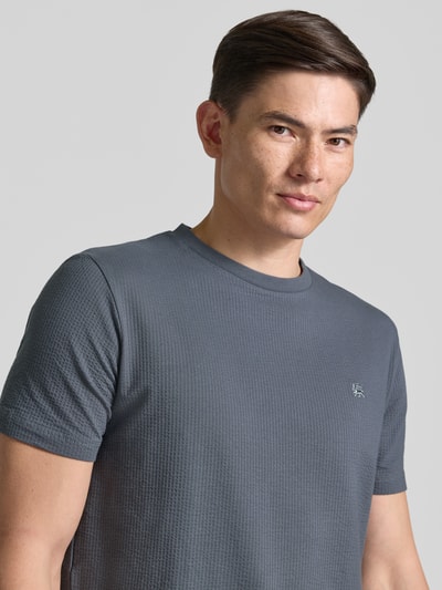 Männermodel trägt T-Shirt mit Strukturmuster und Logo-Stitching von Lerros, Baumwoll-Mix mit Stretch-Anteil, Nahaufnahme Oberkörper.
