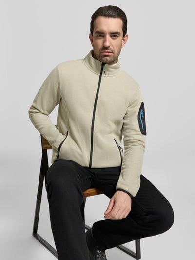 Männermodel trägt Regular fit Fleecejacke mit opstaande kraag Model 'BREDSTEDT' van Icepeak in licht beige met zwarte ritssluiting en steekzakken, context heren fleecejack, schouderbreedte 43 cm, borstwijdte 54 cm, mouwlengte 67 cm, ruglengte 69 cm, nahaufnahme oberkörper.