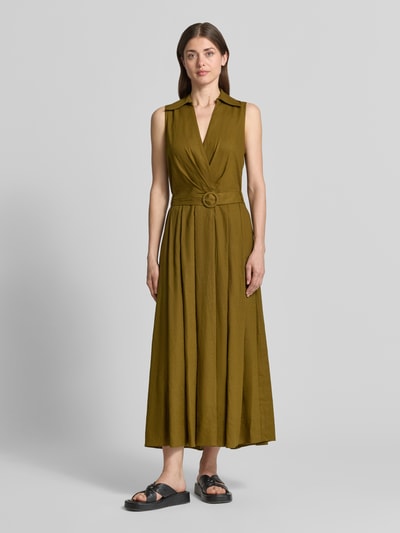Frauenmodel trägt Maxikleid aus Leinen-Viskose-Mix mit Gürtel von Stefanel in Olivgrün, taillierter Schnitt, Wickel-Optik, Hemdblusenkragen, Ganzkörperansicht von vorne.