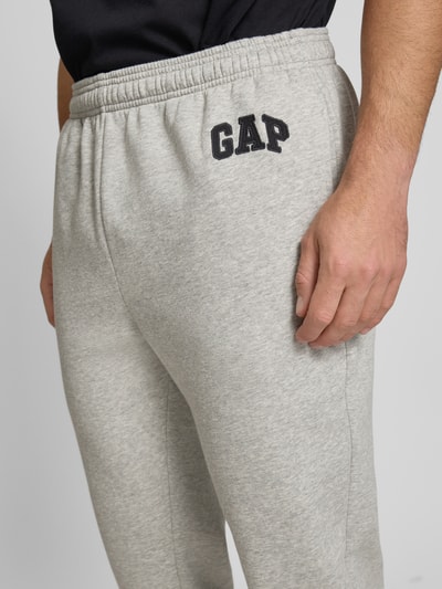 Männermodel trägt Sweatpants mit Logo und elastischem Bund von GAP aus Baumwoll-Mix in Grau, Regular-Fit, Nahaufnahme Oberschenkel.
