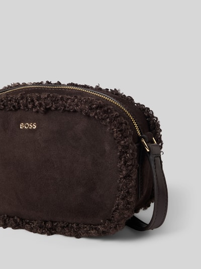 Produktfoto, Umhängetasche mit Teddy-Besatz von BOSS in dunklem Braun, einfarbig, strukturierte Lederoptik, Logo-Detail, Reißverschlüsse, Schulterriemen, Crossbody, sichtbares Hauptfach und Innenfach, geeignet zur Indexierung von Damenaccessoires