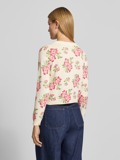 Frauenmodel trägt Boxy Fit Strickpullover aus reiner Baumwolle Modell 'EDITTO' von Weekend Max Mara mit Floral Muster und Intarsie in Strickoptik, Farben Creme und Rosa, gerippte Abschlüsse, Ganzkörperansicht Rückansicht.