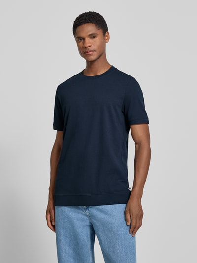 Männermodel trägt Regular Fit T-Shirt aus Baumwoll-Mix von s.Oliver RED LABEL in Dunkelblau, schlichtes Design, Ganzkörperansicht von vorne.