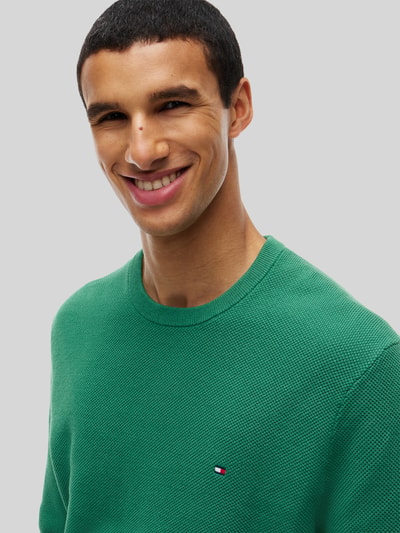 Männermodel trägt Regular Fit Pullover aus reiner katoen von Tommy Hilfiger in grasgroen met fijne textuur, Nahaufnahme Oberkörper