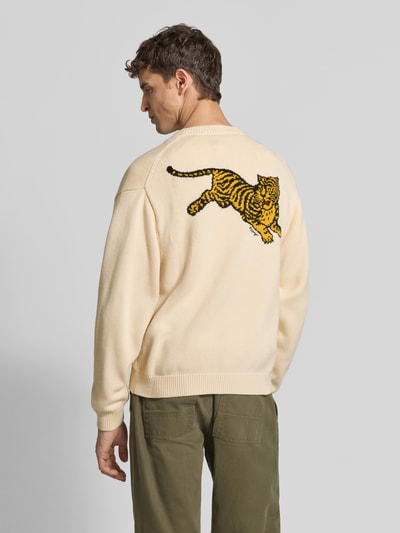 Männermodel trägt Oversized Wolljacke aus Woll-Mix von KENZO, Mieszanka wełny i bawełny, kremowy kolor, wyhaftowany tygrys, prążkowane wykończenia, Ganzkörperansicht Rückansicht