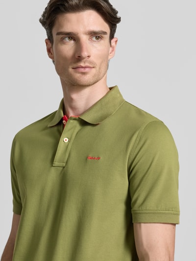 Männermodel trägt Regular Fit Poloshirt mit Logo-Stitching von Gant in Olivgrün, elastischer Baumwoll-Mix, Nahaufnahme Oberkörper.