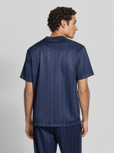Männermodel trägt Regular Fit T-Shirt mit Monogramm-Print von Lacoste in Dunkelblau, glatte textuur, Heren t-shirt, Ganzkörperansicht Rückansicht.