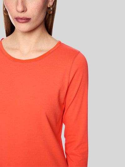 Vrouwenmodel draagt Slim Fit shirt met lange mouwen van katoenmix met boothals en geborduurd logo, Marc Cain, detailopname bovenlichaam, ruglengte maat 36: 58 cm.