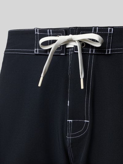Produktfoto, schwarze Regular Fit Shorts mit Logo-Patch Modell 'Arch' von Quiksilver aus elastischem Material-Mix, sichtbarer Schnürverschluss, weiße Kontrastnähte