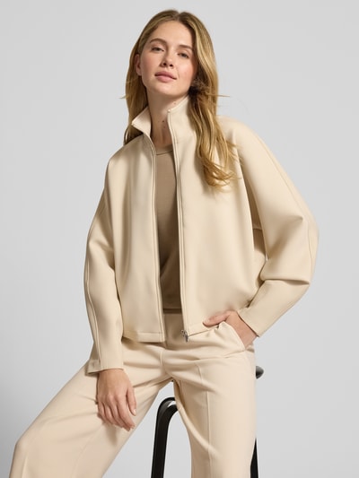 Vrouwenmodel draagt Jacke mit Stehkragen Modell 'Ulara' van Someday in beige materiaalmix met stretch, los model, zijzakken, ritssluiting, opstaande kraag, frontale borst en rugafmetingen, ganzkörperansicht van voren.