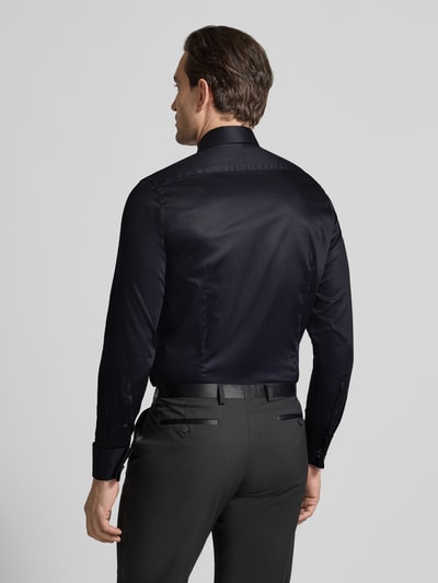 Männermodel trägt Slim Fit Business-Hemd aus Baumwolle mit Kentkragen von Seidensticker in Schwarz, Rückenlänge 77 cm, Ganzkörperansicht Rückansicht.