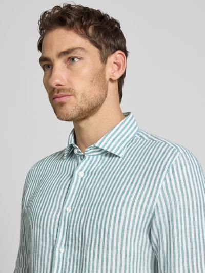 Männermodel trägt Slim Fit Business-Hemd mit Kentkragen von SEIDENSTICKER aus reinem Leinen, Allover-Look, Nahaufnahme Oberkörper. Rückenlänge 76 cm, Schulterbreite 40 cm, Ärmellänge 76 cm. Streifenmuster in Weiß und Grün, glatte Leinen-Textur.