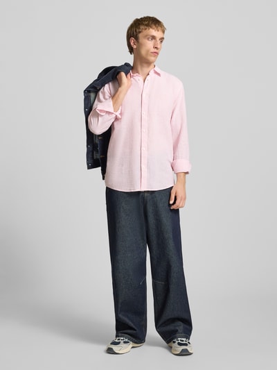 Männermodel trägt Slim Fit Freizeithemd aus Baumwoll-Leinen-Mix Modell 'CAIDENLS SOLID' von Only & Sons in Hellrosa, unifarben, Ganzkörperansicht von vorne.