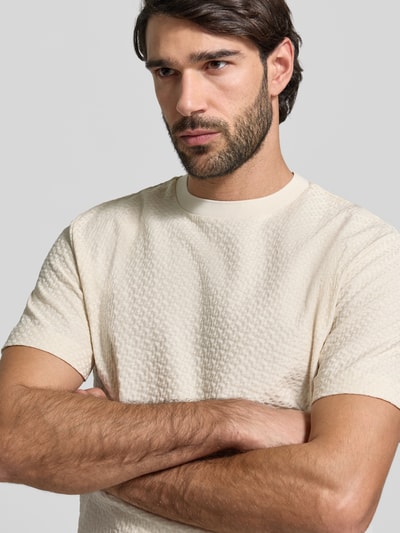 Männermodel trägt Regular Fit T-Shirt aus reiner Baumwolle Modell 'H-Thompson 228' von BOSS, unifarben, Jacquard-Textur, Nahaufnahme Oberkörper.