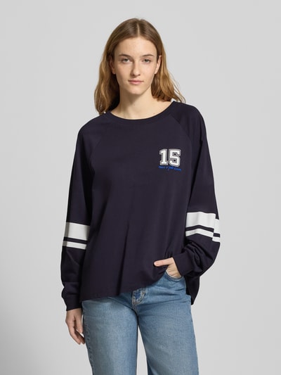 Modelka kobieca nosi Loose Fit Langarmshirt aus reiner Baumwolle od Marc O'Polo Denim, kolor jednolity, długi rękaw, napis, okrągły dekolt, bawełna, widok całej sylwetki z przodu.