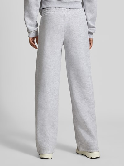 Männermodel trägt Sweatpants mit Häkelspitze von REVIEW in hellgrauer Mieszanka materiałów z mieszanką bawełny, prosty krój, elastyczny pas z tunelem, wyhaftowane logo, szydełkowa koronka, Długość wewnętrzna nogawki w rozmiarze S: 79 cm, Ganzkörperansicht Rückansicht