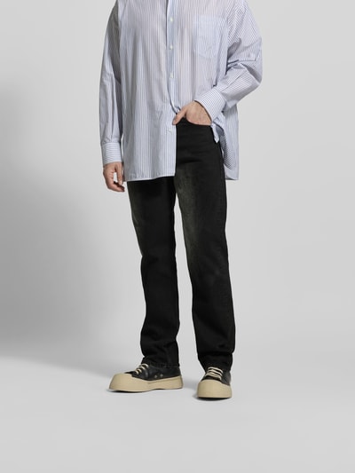 Männermodel trägt Straight Fit Jeans aus reiner Baumwolle von MM6 Maison Margiela in Schwarz mit Used-Look, 5-Pocket-Design, Nahaufnahme Unterkörper.