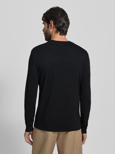 Męski model nosi Longsleeve mit gerippten Abschlüssen von Polo Ralph Lauren, czarna bawełna, regular fit, widok całej sylwetki z tyłu.
