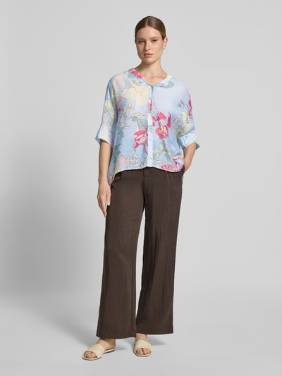 Kobiece modelka nosi Relaxed Fit Bluse aus Viskose-Mix im Allover-Look von comma, mieszanka wiskozy, krój relaxed fit, wzór na całej powierzchni, dekolt w serek, rękaw o dł. 3/4, wydłużony tył, listwa guzikowa, długość tyłu w rozmiarze S: 64 cm, długość rękawów w rozmiarze S: 24 cm, widok całej sylwetki z przodu.