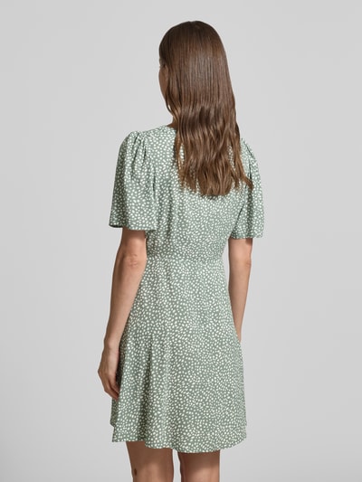 Kobiece model prezentuje lekko rozkloszowaną sukienkę mini z czystej wiskozy Leicht ausgestelltes Minikleid aus reiner Viskose Modell 'ALBA' od Vero Moda, kolor jednolity, pasek w talii, krótki rękaw, faktura gładka, widok całej sylwetki od tyłu.
