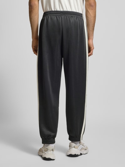 Männermodel trägt Sweatpants mit elastischem Bund von adidas Sportswear, Baumwoll-Mix, Lockerer-Schnitt, Label-Print, Eingrifftaschen, Ganzkörperansicht Rückansicht.