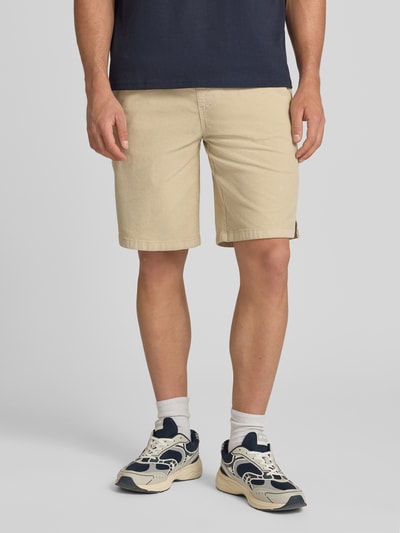 Männermodel trägt Regular Fit Shorts mit Tunnelzug Modell 'Joey' von Redefined Rebel aus Baumwoll-Elasthan-Mix in Beige, Cord, Nahaufnahme Oberkörper bis Knie.