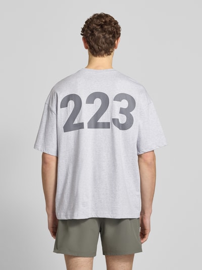 Männermodel trägt T-Shirt mit Label-Print und Rundhalsausschnitt von HALO, reine Baumwolle, boxy fit, Rückansicht, Ganzkörperansicht.