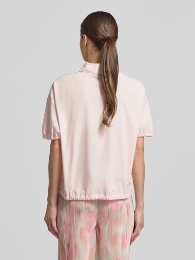 Männermodel trägt Regular Fit Bluse mit Polokragen von Marc Cain z bawełny, krój regular fit, elastyczne zakończenia rękawów, z krótkim rękawem, pas z tunelem, długość tyłu 59 cm, długość rękawów 19 cm, pastelowe kolory, tekstura gładka, widoczne lekkie marszczenia, całkowity widok z tyłu