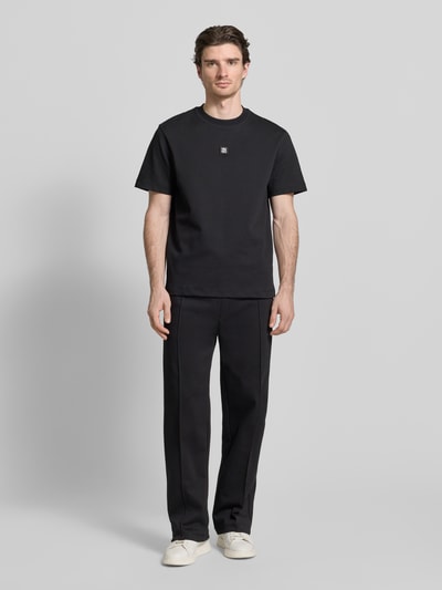 Męski model nosi Regular Fit Sweatpants aus Baumwoll-Mix Modell 'DINETO' von HUGO, efekt: jednolity kolor, krój regular fit, naszywka z logo, kanty, elastyczny ściągacz z tunelem, wpuszczane kieszenie boczne, kieszeń z tyłu, wykończenie: dzianina dresowa, mieszanka bawełny, ganzkörperansicht od frontu.