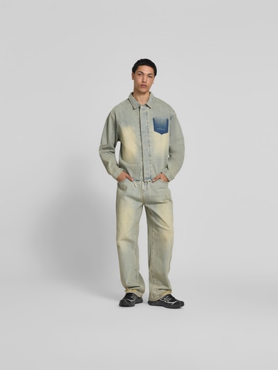 Männermodel trägt Hemdjacke in Denim-Optik von Don’t Waste Culture aus reiner Baumwolle, Relaxed Fit, Kentkragen, Statement-Print, Ganzkörperansicht von vorne.