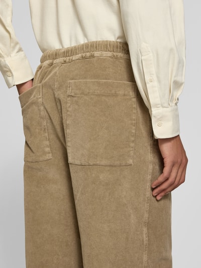 Männermodel trägt Cordhose mit Stretch-Anteil von Officine Générale, Baumwoll-Elasthan-Mix, Relaxed Fit, Nahaufnahme Rückansicht.