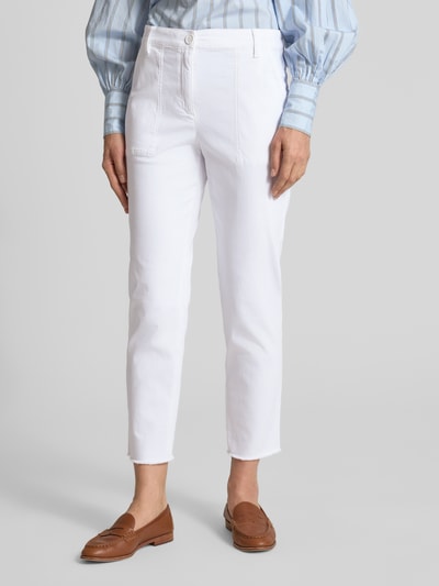 Kobiece model prezentuje chinosy Chino mit Fransensaum von Marc Cain, mieszanka bawełny z dodatkiem streczu, krój slim fit, zapięcie na guzik i zamek błyskawiczny, wpuszczane kieszenie, frędzle na dole, kieszenie z tyłu, szerokość w rozmiarze 36: 40 cm, długość wewnętrzna nogawki w rozmiarze 36: 67 cm, kolor biały, faktura gładka, widok z przodu na całe nogi.