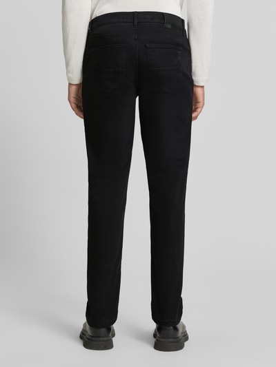 Männermodel trägt Regular Fit Weite Hose aus Baumwoll-Mix mit Lyocell-Anteil von Brax in Schwarz, glatte Struktur, Ganzkörperansicht Rückansicht, Herren Weite Hose von Brax.